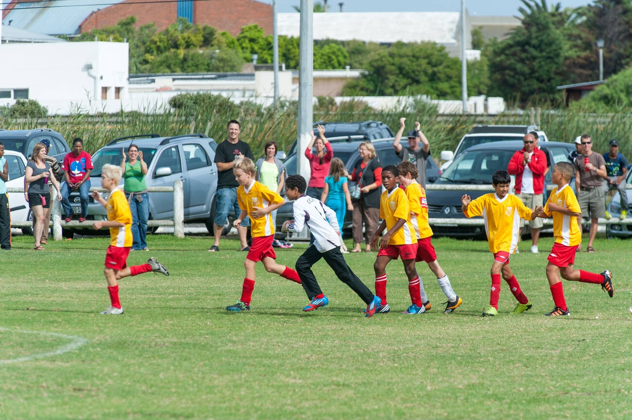 parents supporting kids playing football